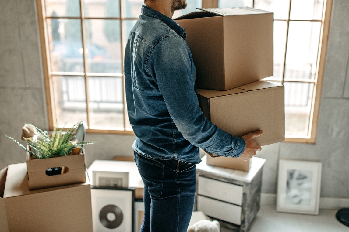 adult carrying moving boxes 