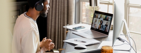man on video call at desk working from home 